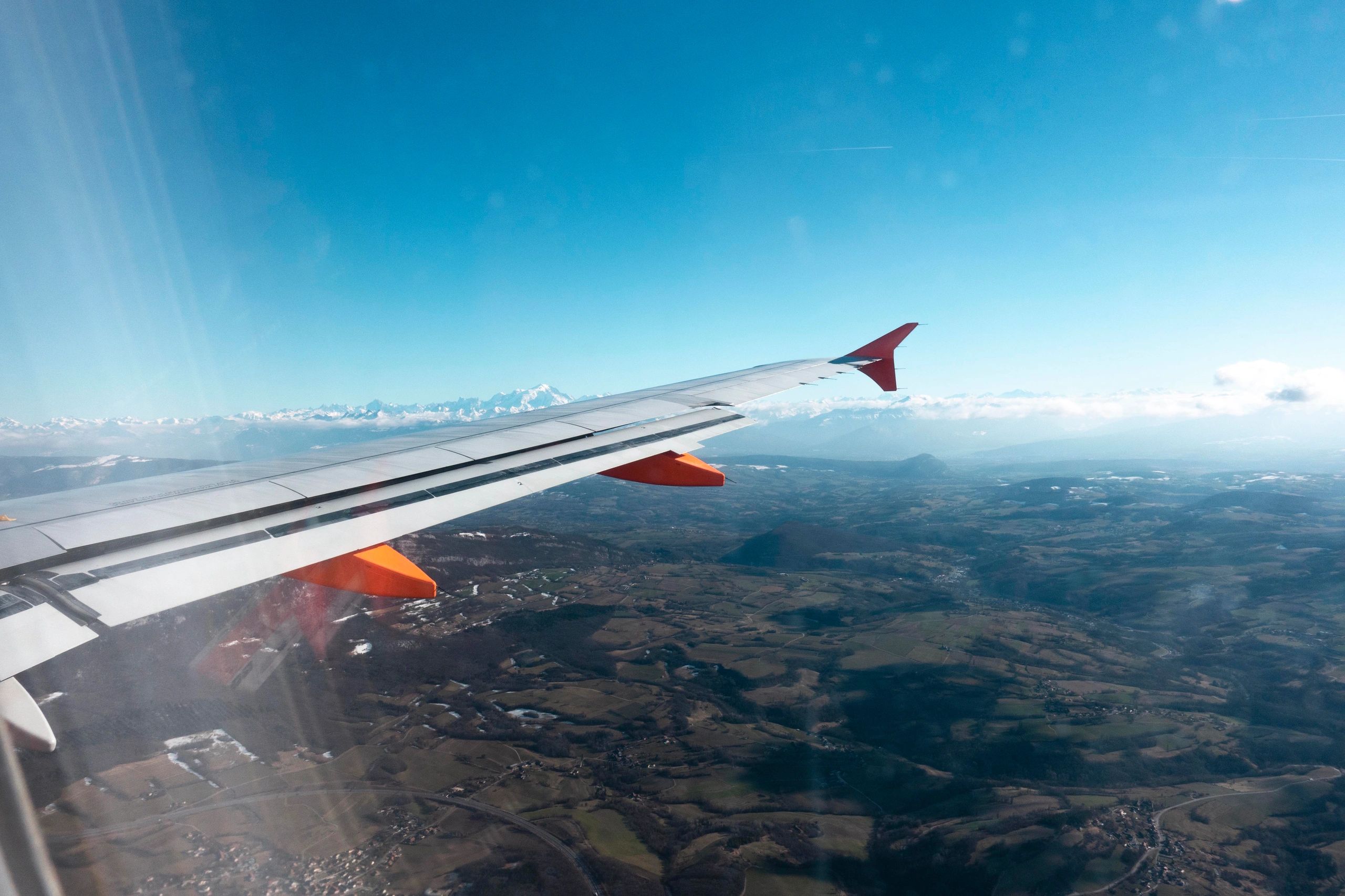 View from an airplane window over mountains and clouds