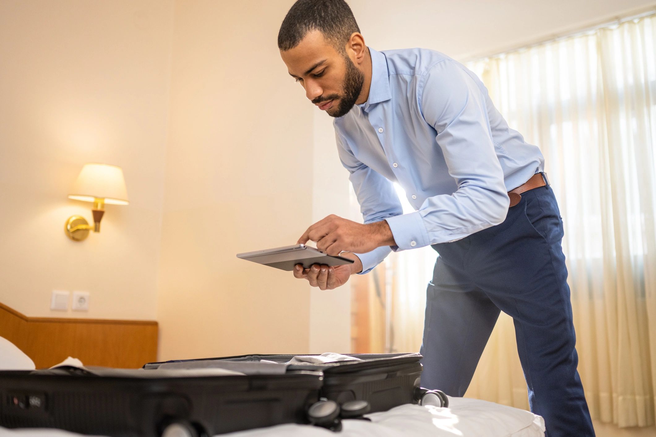 Traveler using a tablet while preparing for a trip